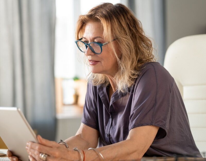 Woman holding a tablet to Know About Changes to Superannuation Tax Concessions and Their Impact on Estate Planning