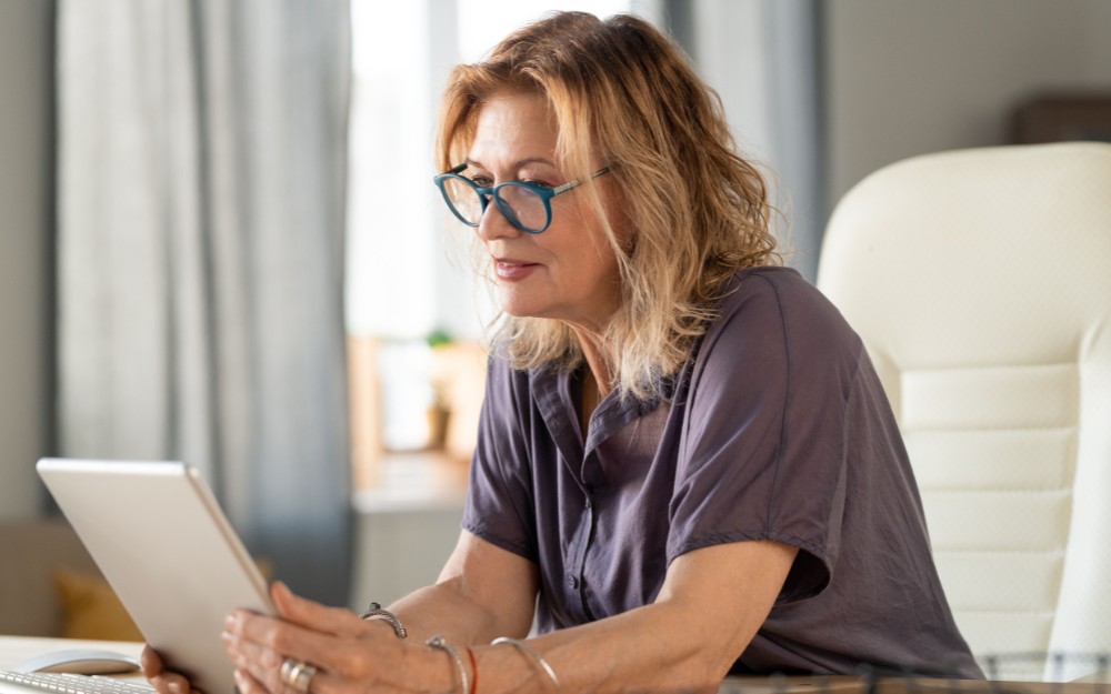 Woman holding a tablet to Know About Changes to Superannuation Tax Concessions and Their Impact on Estate Planning